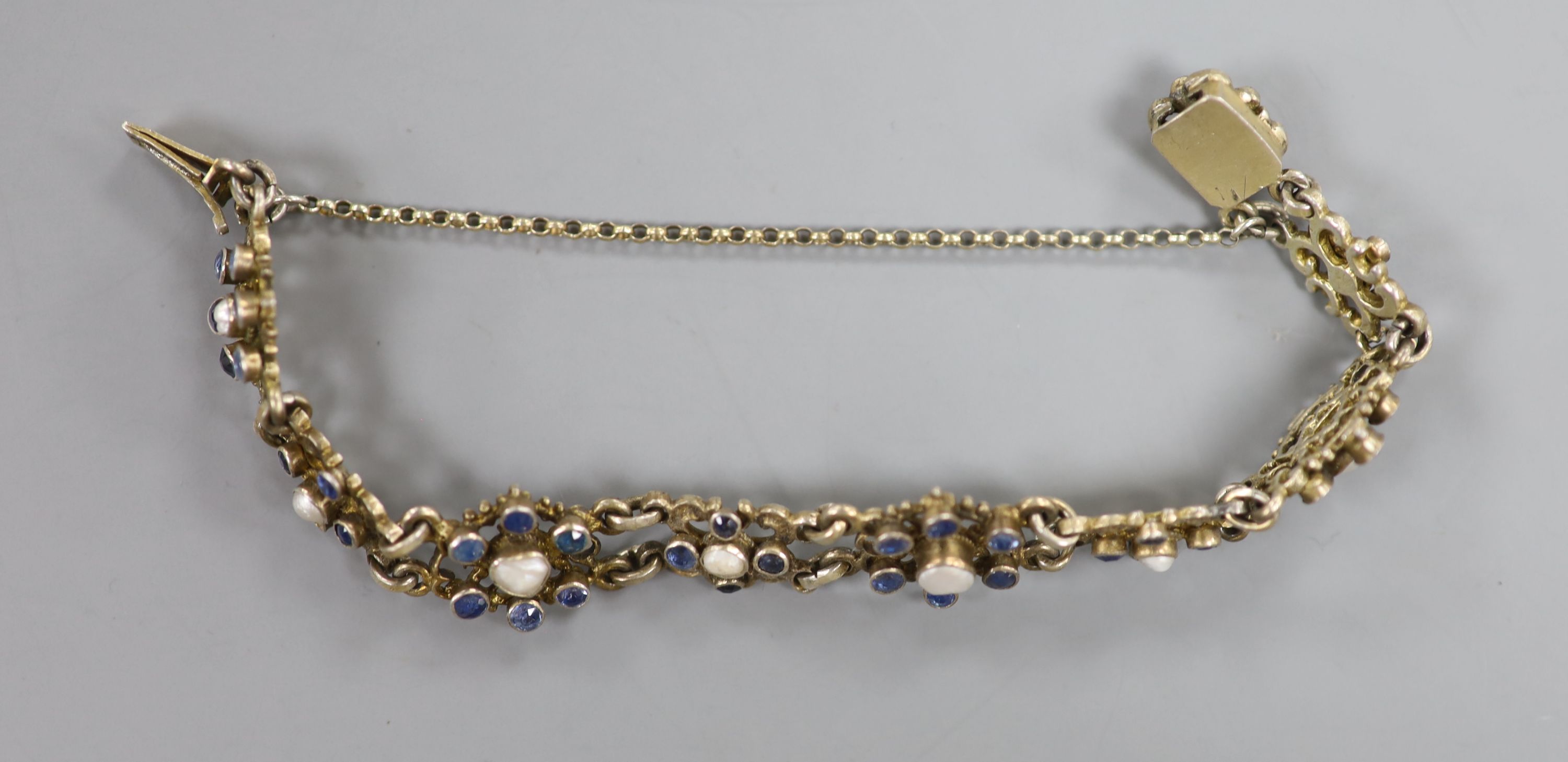 A continental gilt white metal, sapphire and split pearl flower head cluster set bracelet